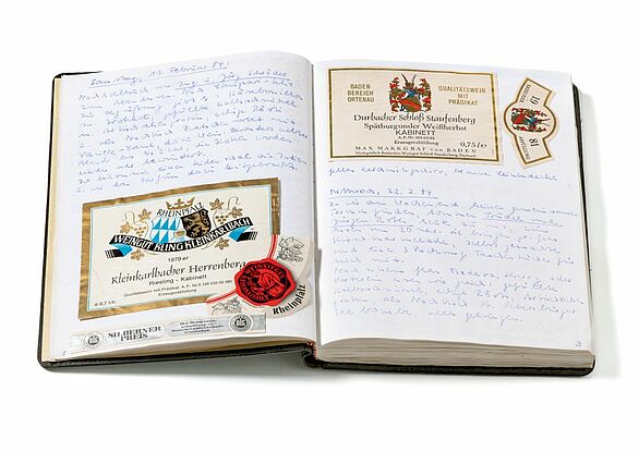 Aufgeschlagendes Gästebuch mit handschriftlichem Text und eingeklebten Erinnerungen